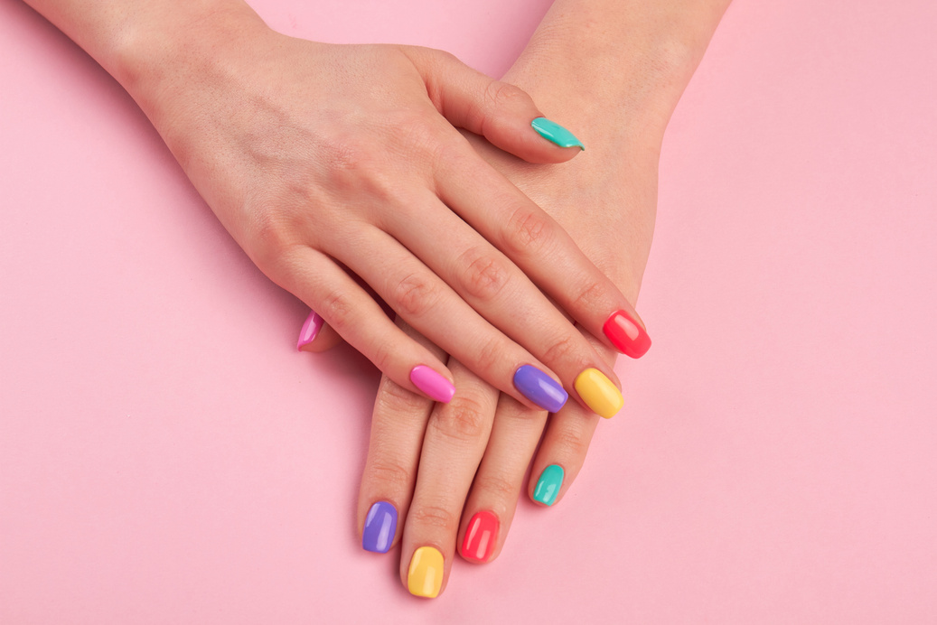 Female hands with colorful polish nails.